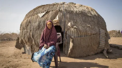 Ibadha zit op een stoel voor haar huis