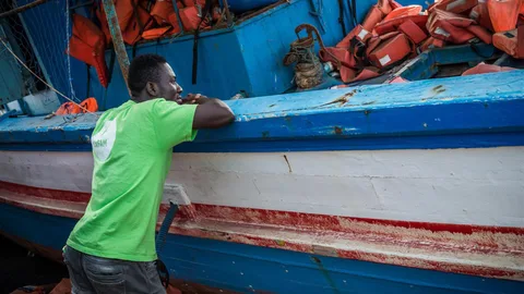 Mahamudi staat bij een boot.