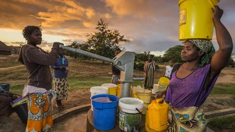 Elsa bij een bron met een emmer op haar hoofd.