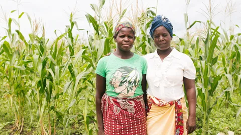 Amelia en Virginia staan voor een akker met gewassen.