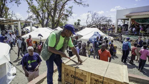 Iemand opent een krat met hulpgoederen van Oxfam.