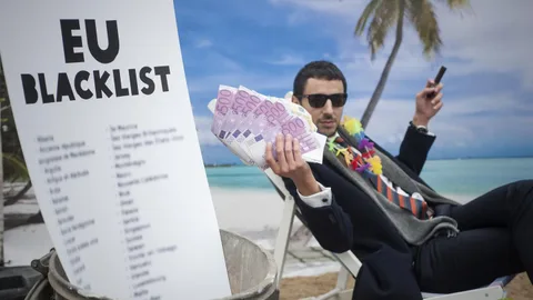 Een man in pak op een tropisch strand met briefjes van 500 euro in zijn hand. Op de voorgrond een papier met de tekst EU Blacklist.