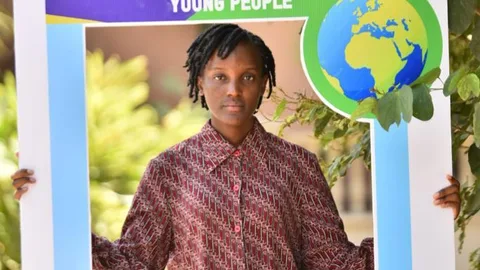 Vanessa Nakate met een bord met de tekst: No climate justice without gender justice & young people.