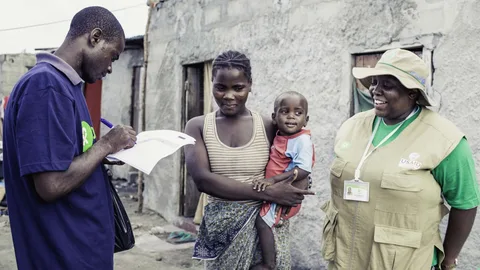 Janette en haar zoontje met twee medewerkers van Oxfam.