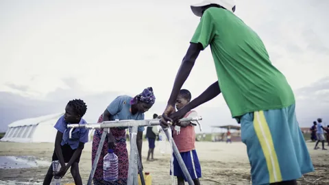 Mensen met jerrycans bij een waterpunt.