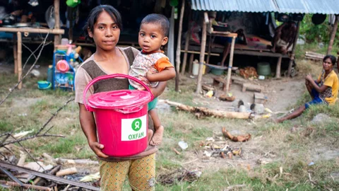 Foto van moeder met kind op Sulawesi met hygiëne kit van Oxfam.