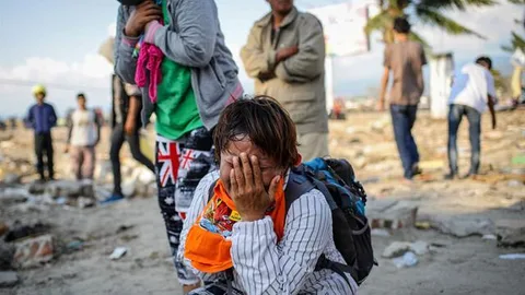Foto van een vrouw die rouwt om haar overleden familieleden.