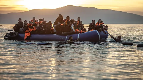 Foto van vluchtelingen in een opblaasboot die aankomen in Griekenland.
