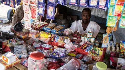 Modou in zijn winkel met eten.