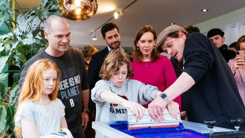 Foto van kinderen die t-shirts bedrukken in de 'sweatshop' in Den Haag.
