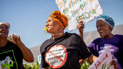 Zuid-Afrikaanse vrouwen voeren actie voor betere arbeidsrechten, met protestborden, fluitjes en leuzen op t-shirts.