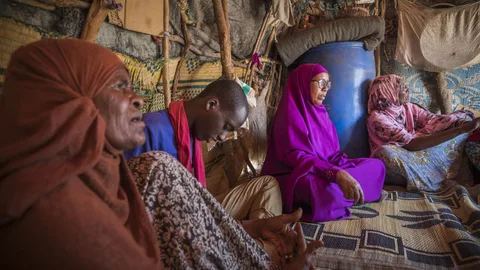 Een groep mensen zit in een hut.
