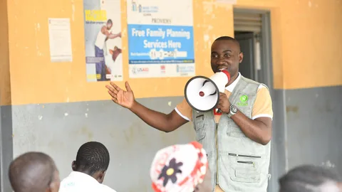 Joseph spreekt in een megafoon bij een van de regionale ziekenhuizen.