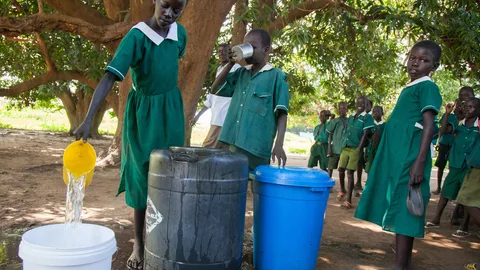 Foto van schoolkinderen in Zuid-Soedan die schoon water en voorlichting krijgen over hygiëne om choleraverspreiding te voorkomen.