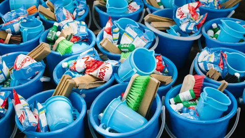 Foto van blauwe emmerr met daarin schoonmaakspullen.