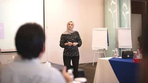 Lona presenting in front of two flipboards.