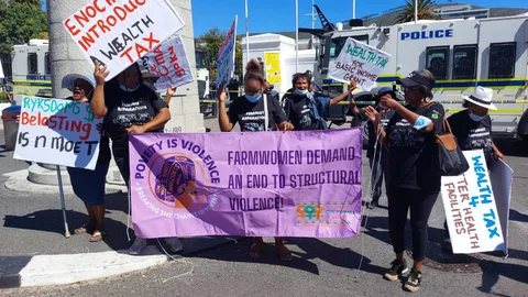 People in South Africa with signs protesting for wealth tax.
