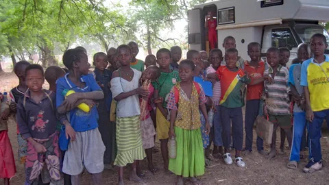 Een groep Afrikaanse kinderen staat voor de camper van de familie Meijer.