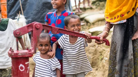 Kinderen bij een waterpomp.