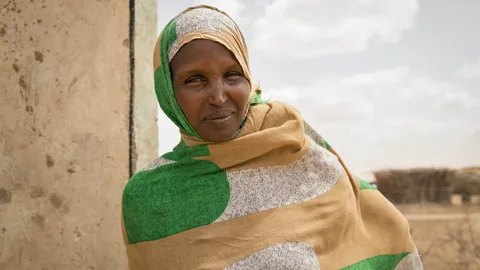 Een Keniaanse vrouw draagt een doek om haar hoofd en lichaam.