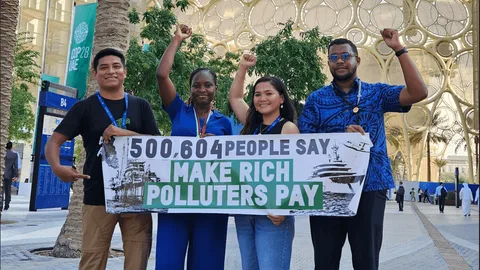 Demonstrators with a banner saying: 500,604 people say make rich polluters pay