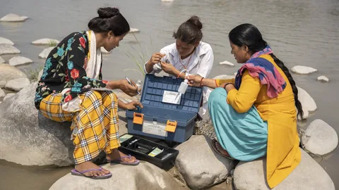 Anjala Devi Bohra en twee vrouwen testen het rivierwater.