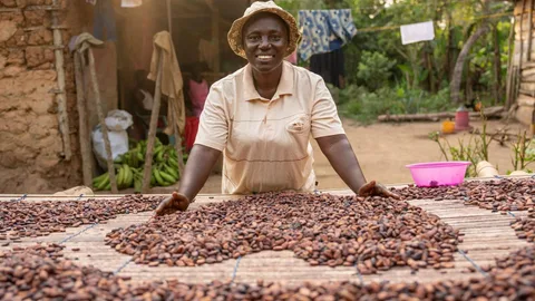 Cacaoboer Leticia met een hart gevormd door cacaobonen op een tafel.