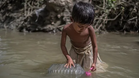 Een jongen uit het Unchiprang vluchtelingenkamp haalt water op uit een vervuilde rivier