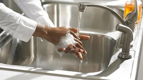 Handen wassen onder een lopende kraan.