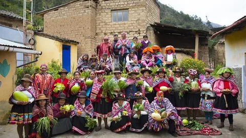 Groepsfoto van boeren. Enkele houden groente vast.