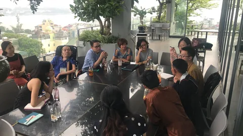 Foto van een groep Vietnamese jongeren in gesprek rond een tafel