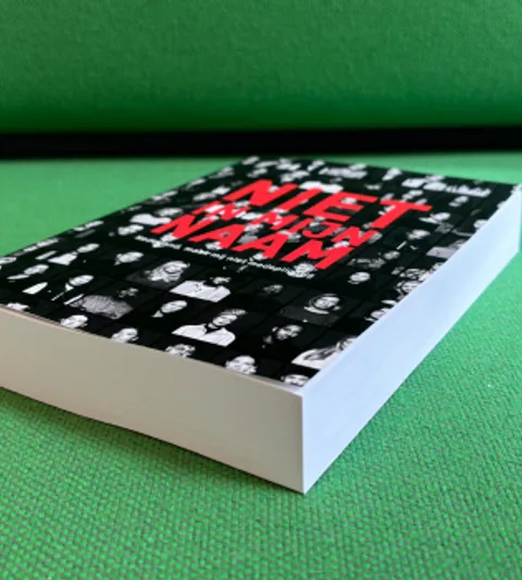 Boek "Niet in mijn naam" met handtekeningen van de petitie ondertekenaars van Gaza op een Groen stoffen bank
