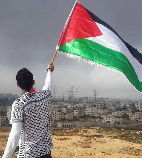 Iemand zwaait met een Palestijnse vlag.