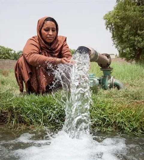 A woman next to a water hose.