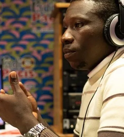 A man wearing head phones in front of a radio microphone.