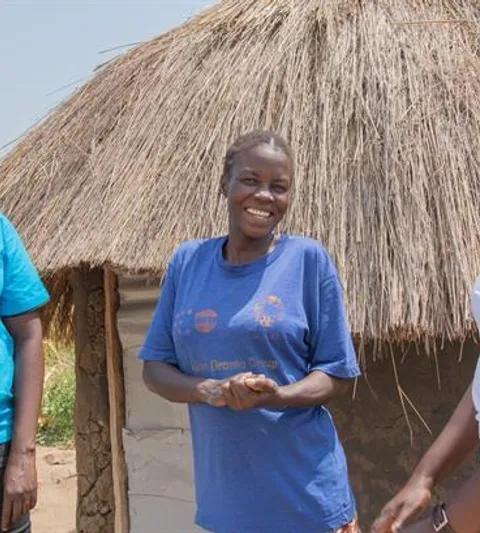 Women standing in front of a hut.