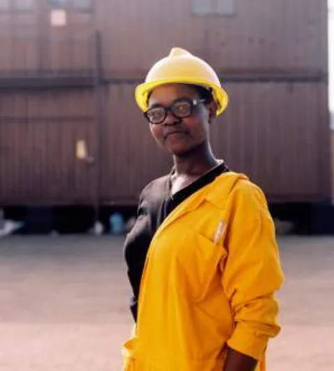 A women wearing a protective helmet and overalls.