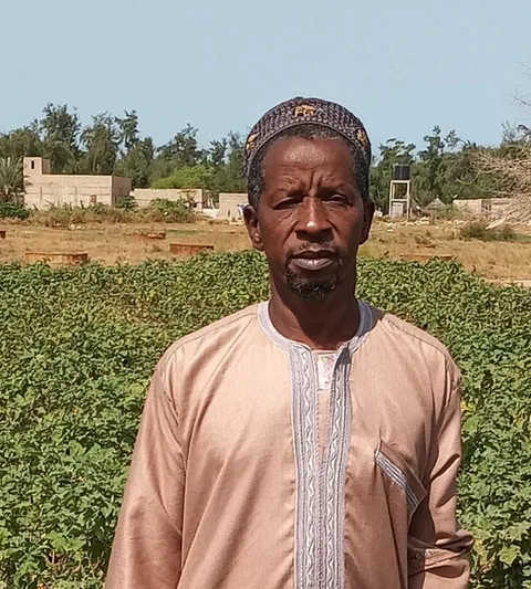Farmer Abdou in front of a field.