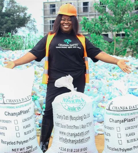 Olufunto Boroffice, the founder and CEO of Chanja Datti, posing next to bags of waste.