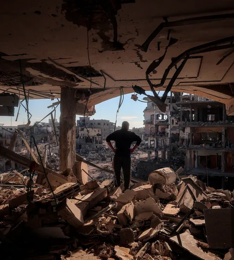 Man staat in zijn verwoeste appartement in Gaza