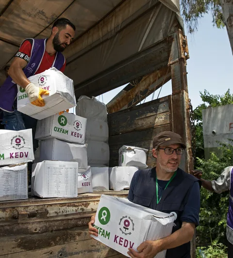 Hulpverleners laden noodhulppakketten uit een vrachtwagen.