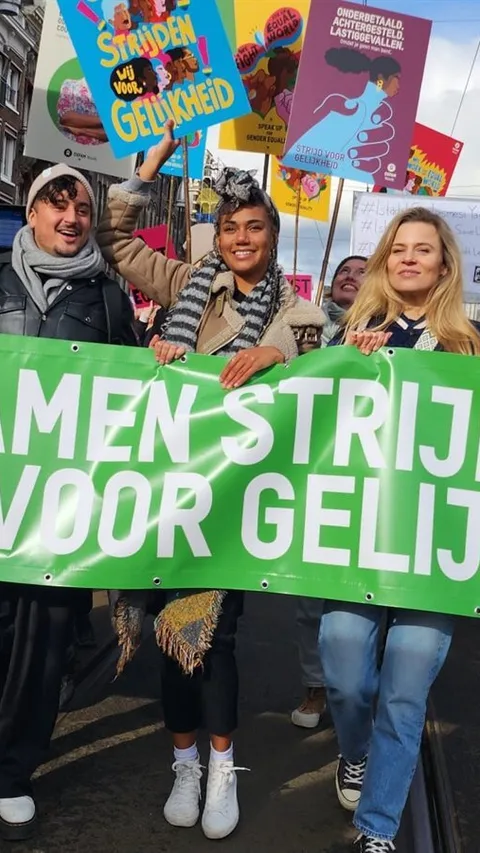 Vrouwen tijdens de Feminist March houden een spandoek vast met de tekst: Samen strijden wij voor gelijkheid