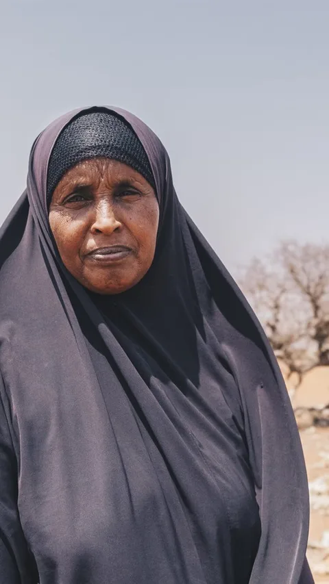 Mareya uit Kenia staat op een zandvlakte.