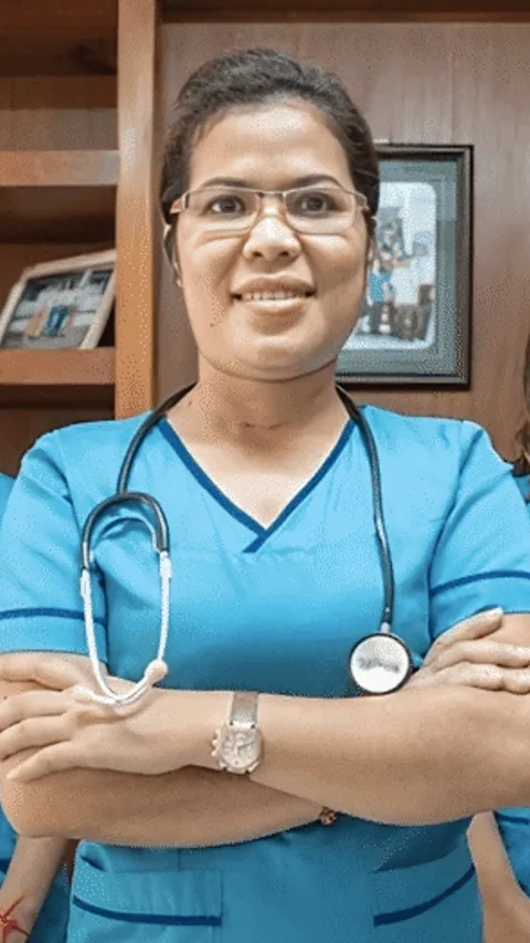 Phirum heeft een stethoscoop om haar nek. Links en rechts van haar staan een aantal zusters.