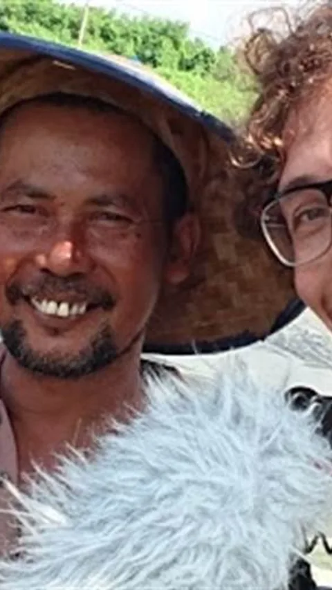 Guido Castagna met naast hem iemand met een hoed die zwaait.