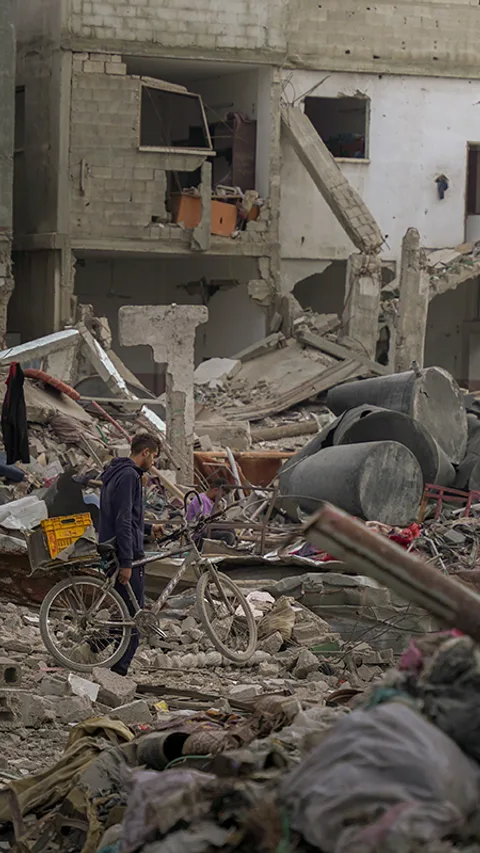 Een man uit Gaza op weg naar wat over is van zijn huis temidden van verwoeste gebouwen
