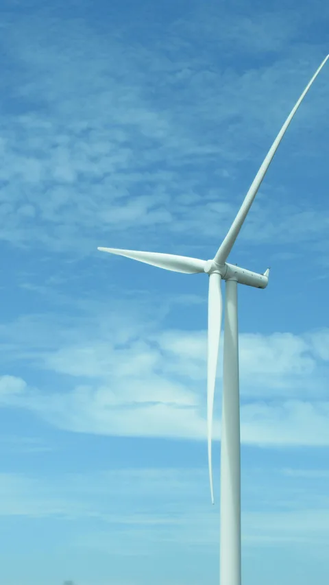 Een windmolen met op de achtergrond een blauwe lucht