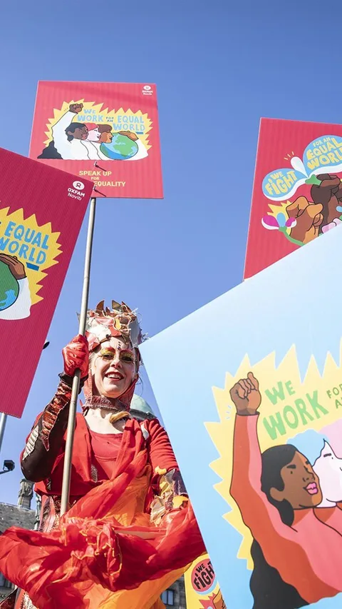 Een vrouw met protestborden voor gendergelijkheid