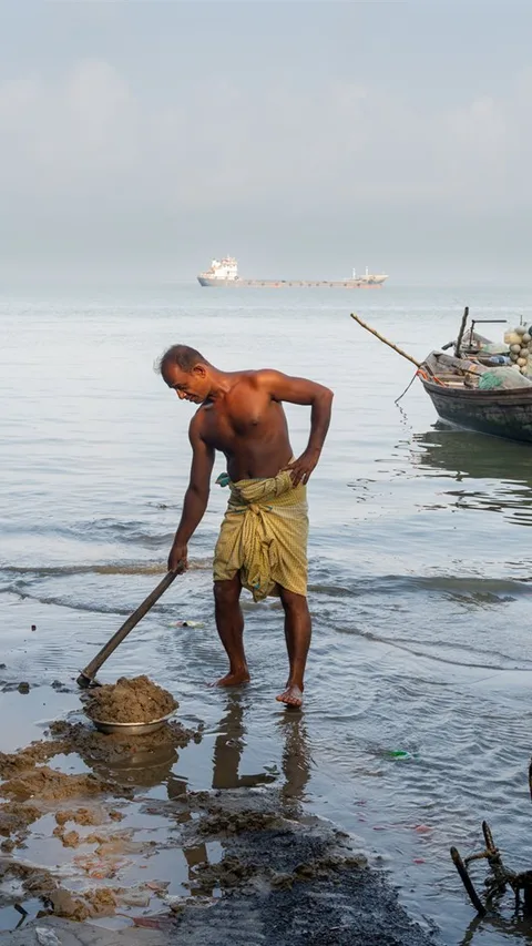 Een visser staat tot aan zijn enkels in het water