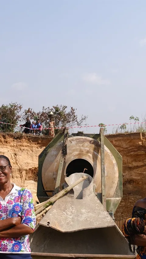 Virginia en een andere vrouw staan naast een machine.